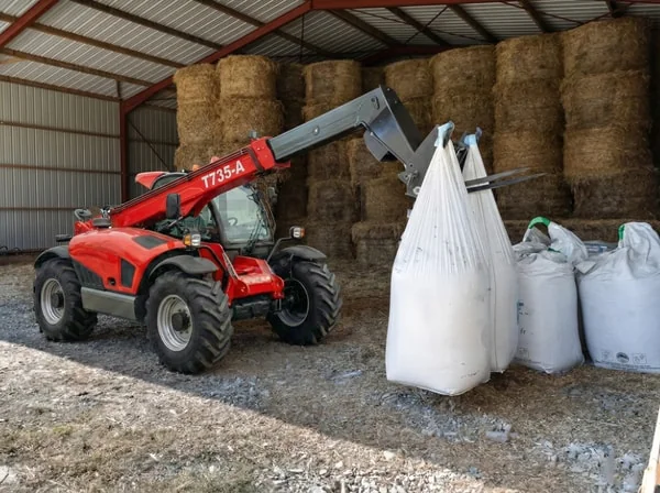 T735-A telehandler loading farm storage shed