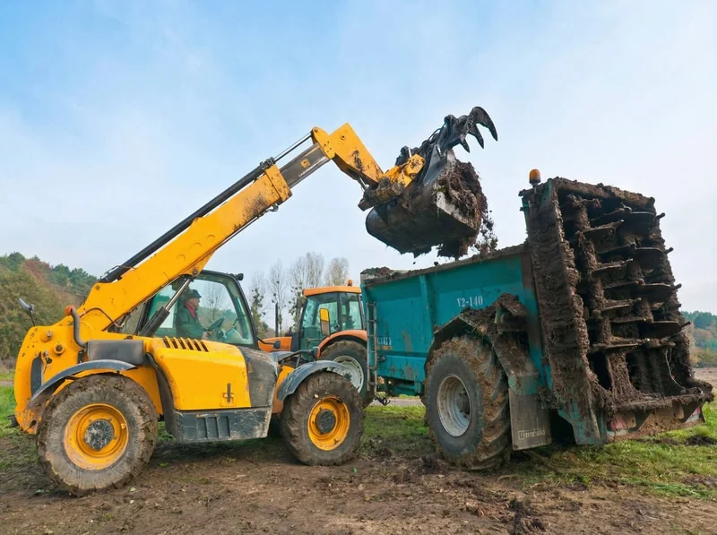 Telehandler manure handling and cleaning in livestock environment